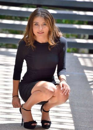 Молоденькая милашка в обтягивающем платье и на каблуках вставляет большой огурец в киску